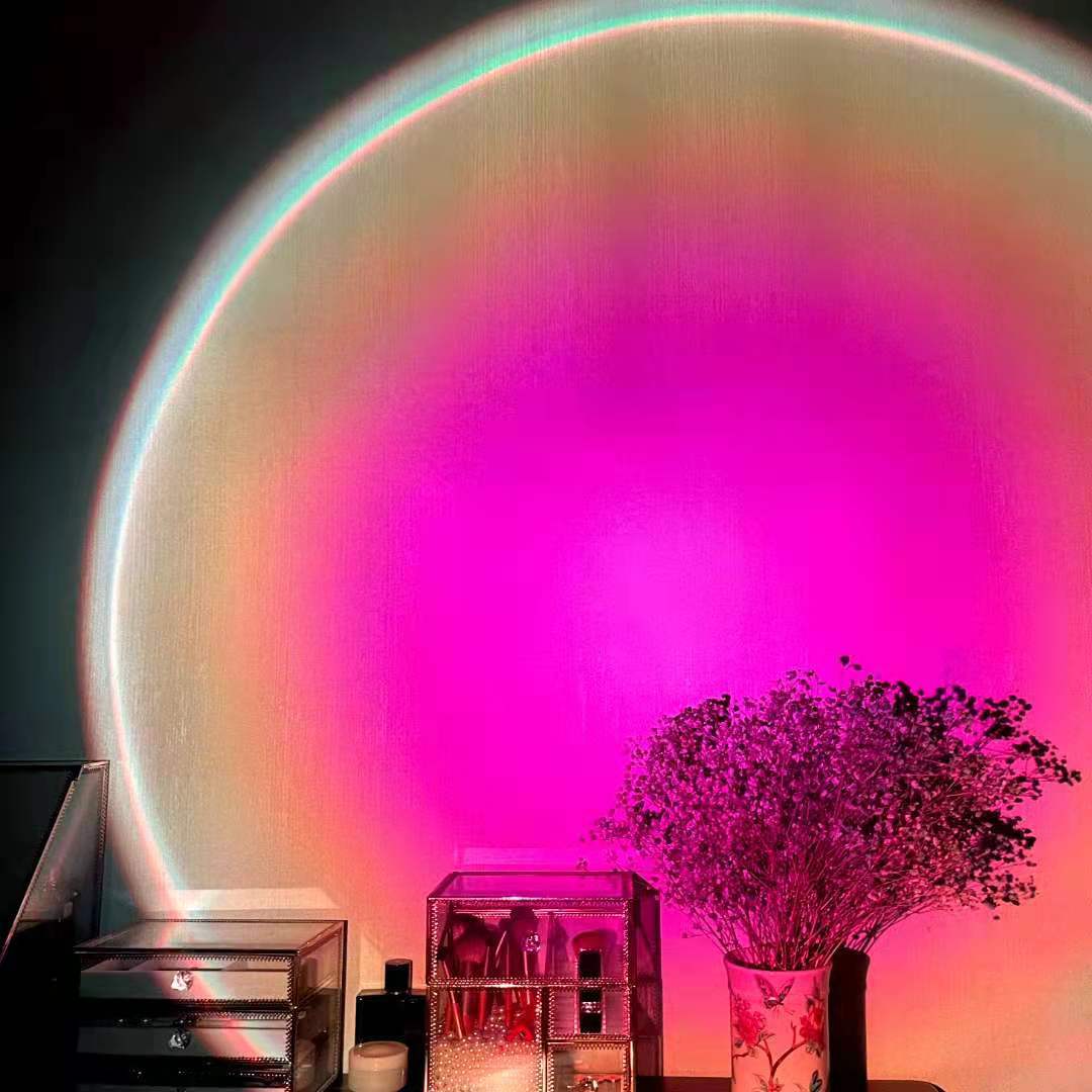 Sunset projection lamp casting warm rainbow glow across bedroom wall